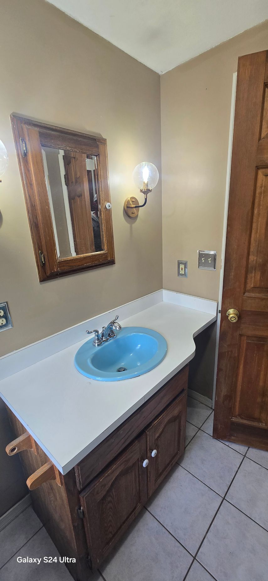 A bathroom with a sink , mirror and toilet.