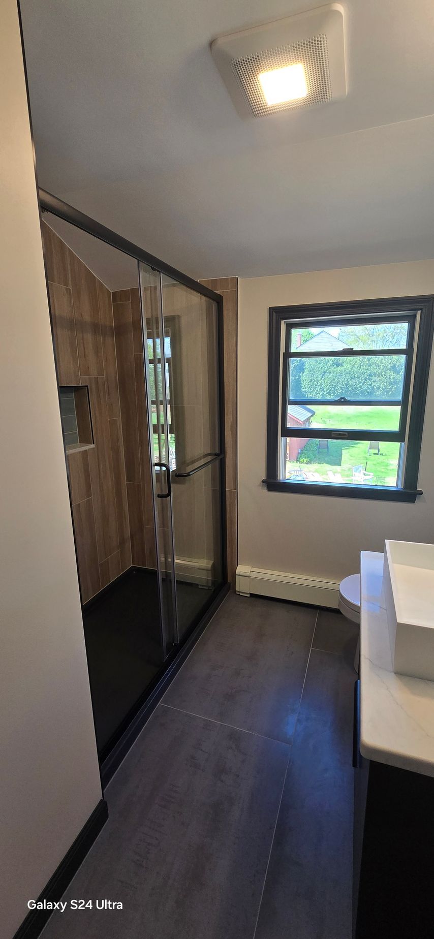 A bathroom with a sink , toilet , and window.