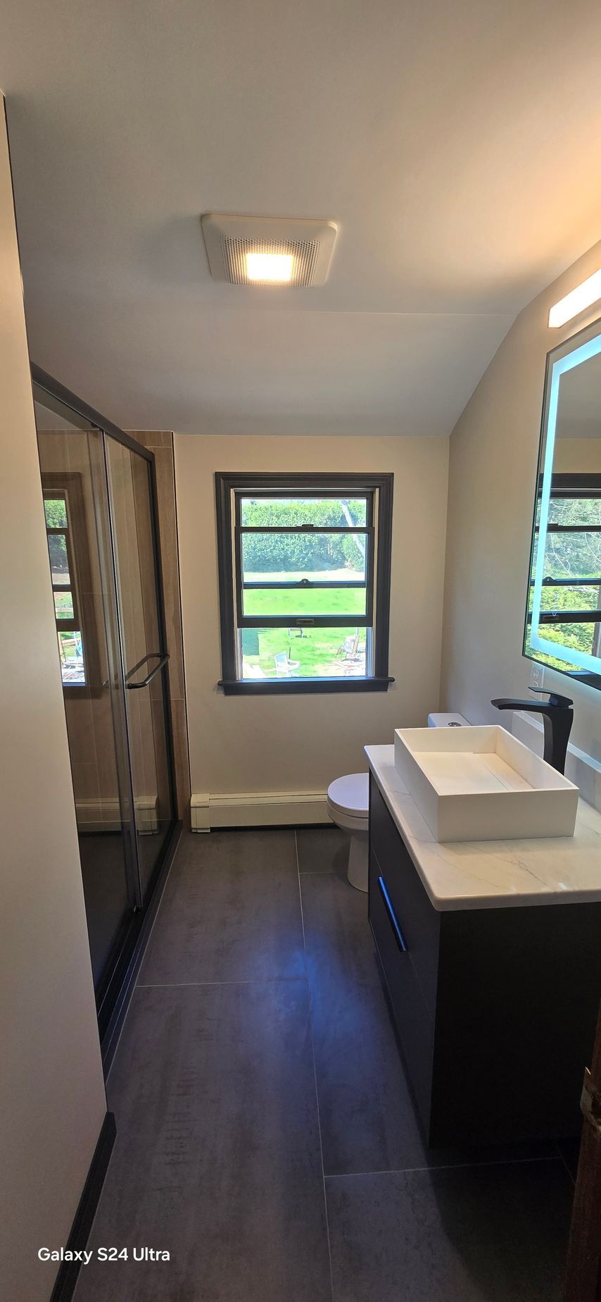 A bathroom with a tub , toilet , sink and mirror.