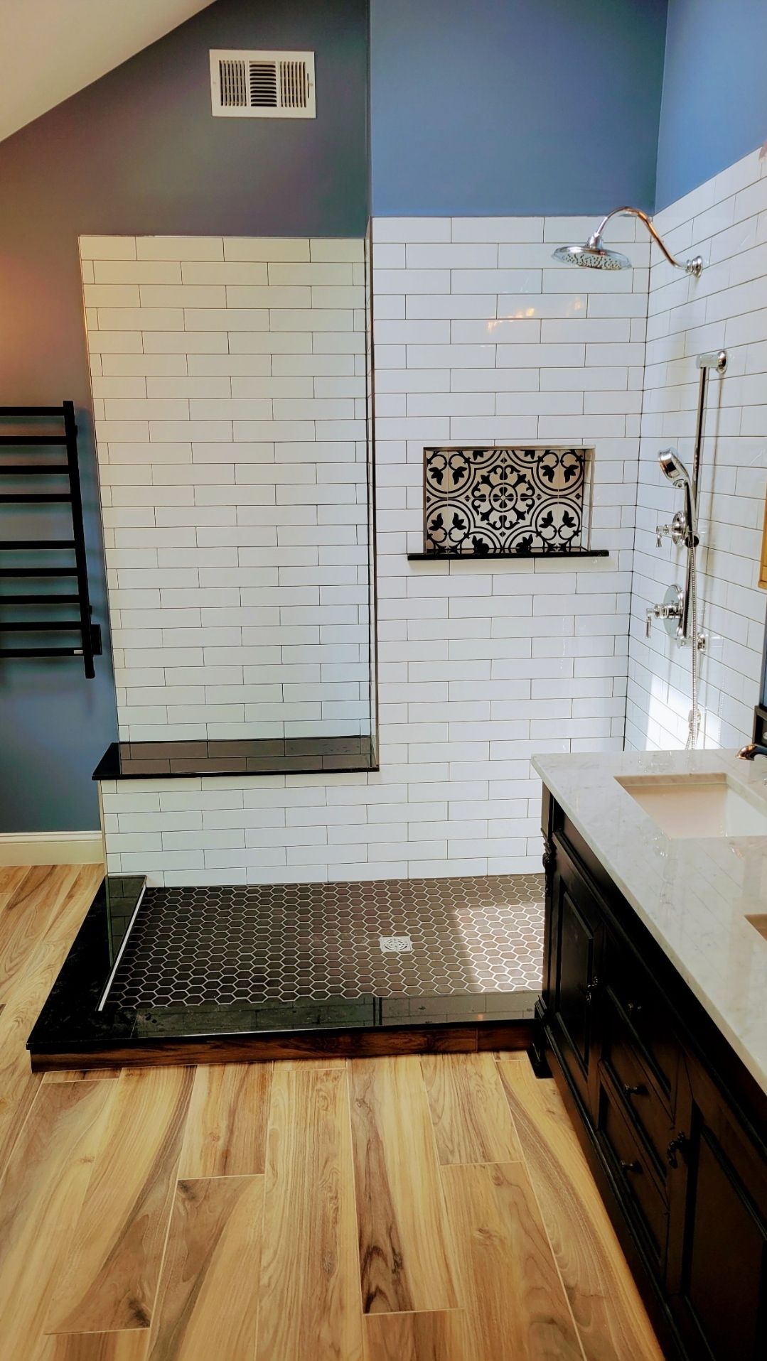 A bathroom with a walk in shower and a sink.