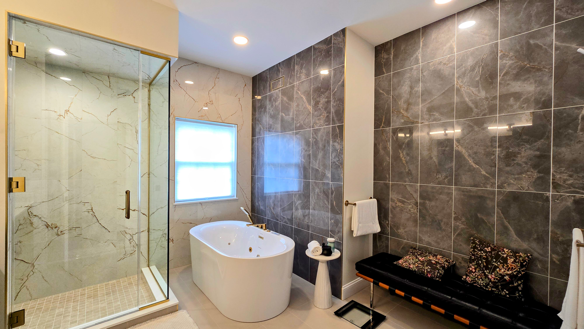 Modern bathroom in Cromwell, CT with glass shower, freestanding tub, and dark tiled wall with fireplace