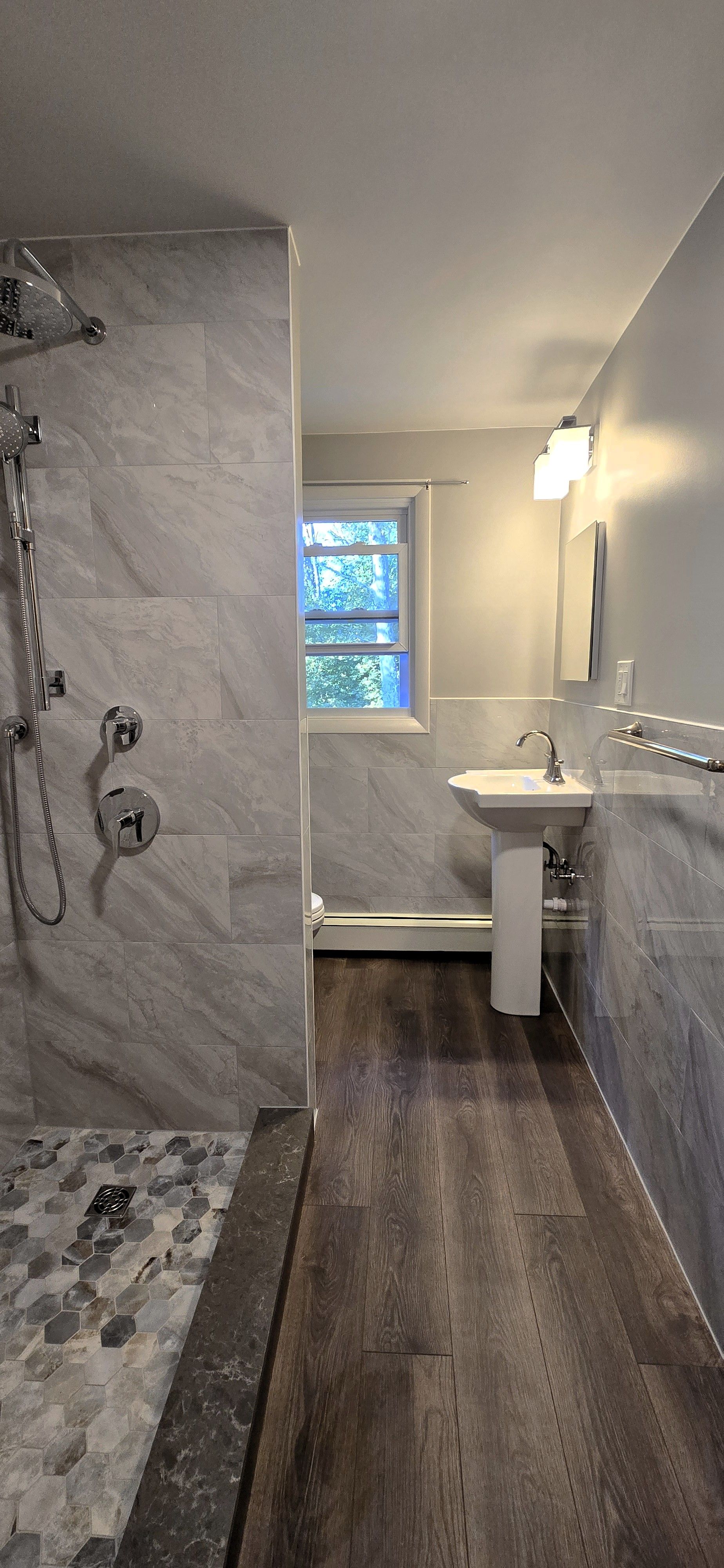 White Southington bathroom with vanity, lit mirror, and open door.