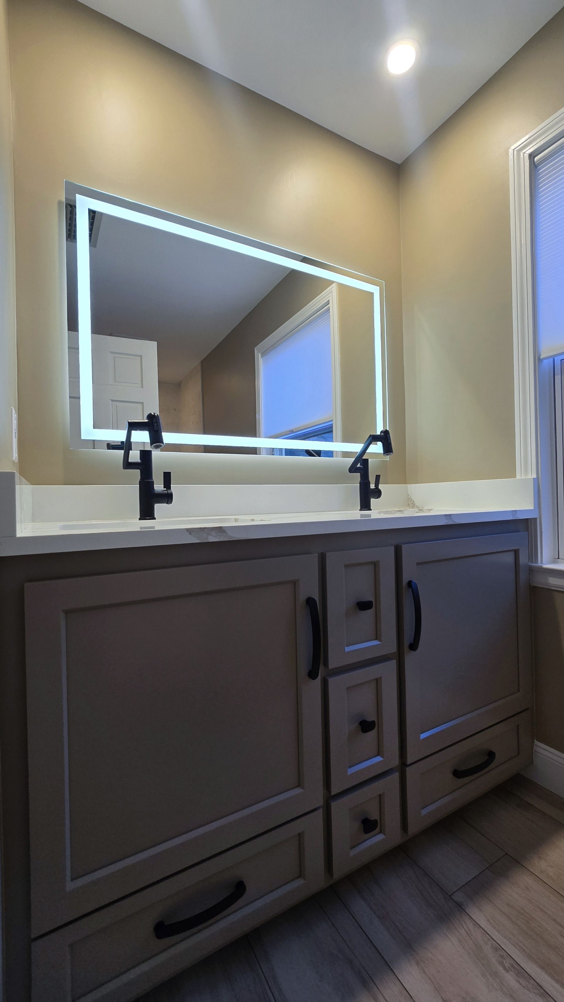 Modern Bristol bathroom vanity with a lighted mirror and black faucets.