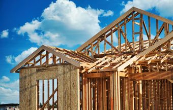 Une maison est en construction avec un ciel bleu en arrière-plan.
