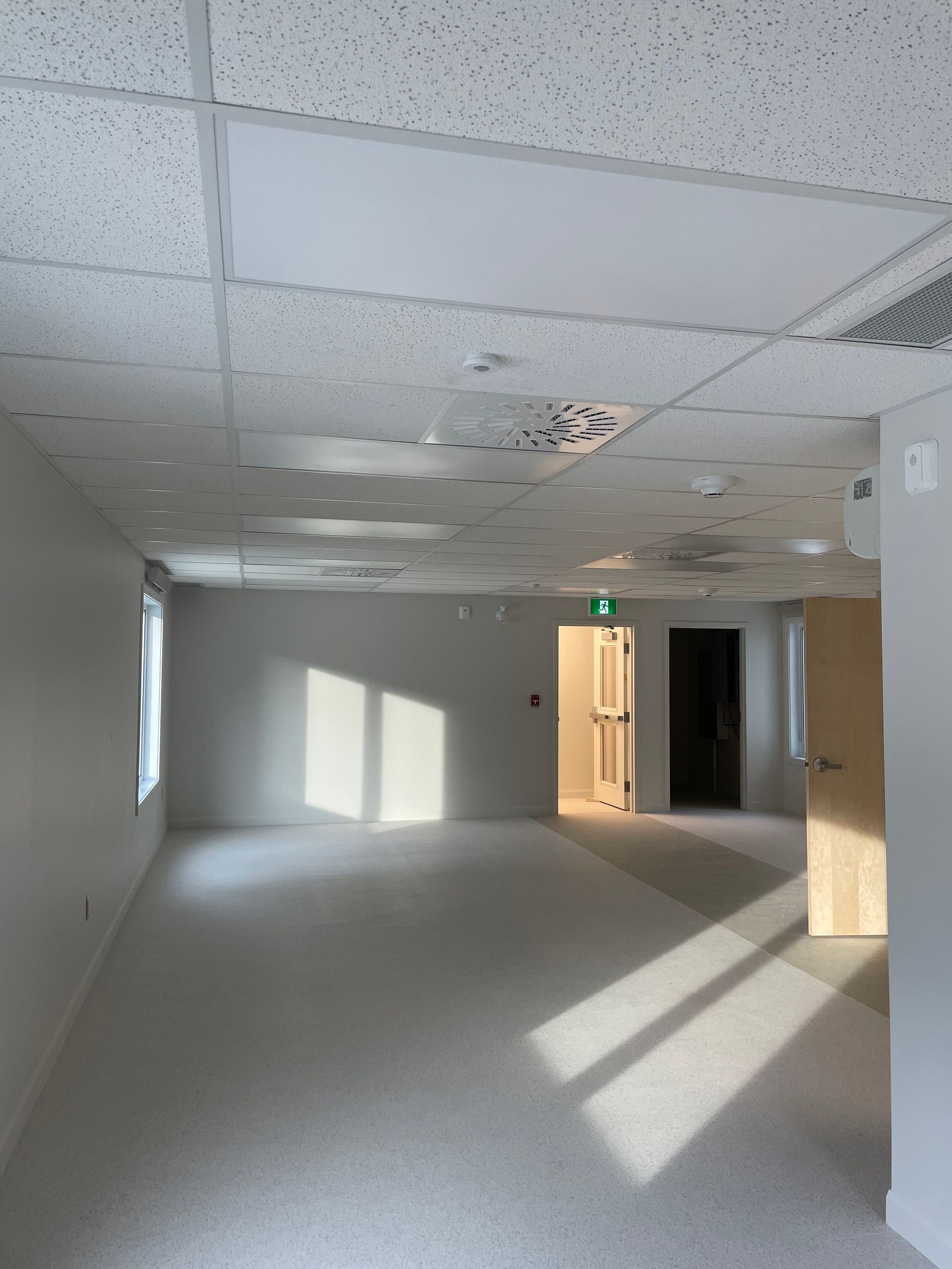 Une pièce vide avec un panneau de sortie vert au plafond