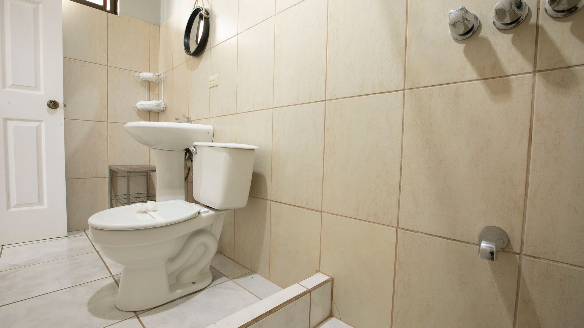 a bathroom with a toilet , sink and shower .
