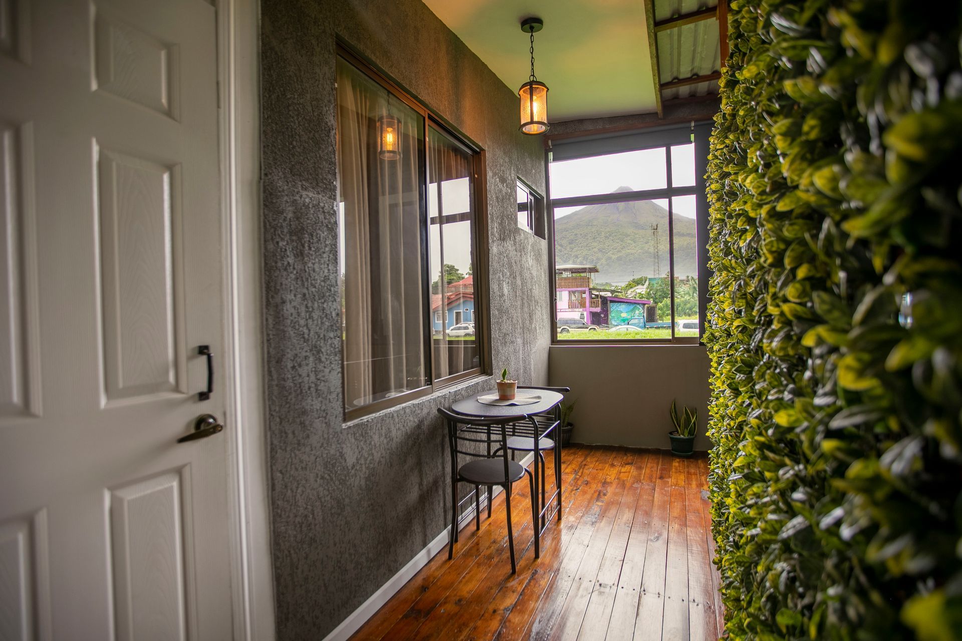 a hallway with a table and chairs and a green wall .