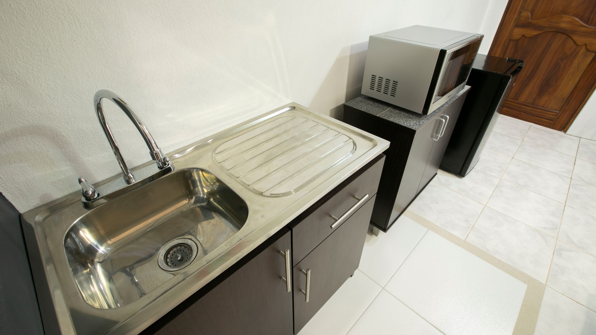 a kitchen with a stainless steel sink and a microwave