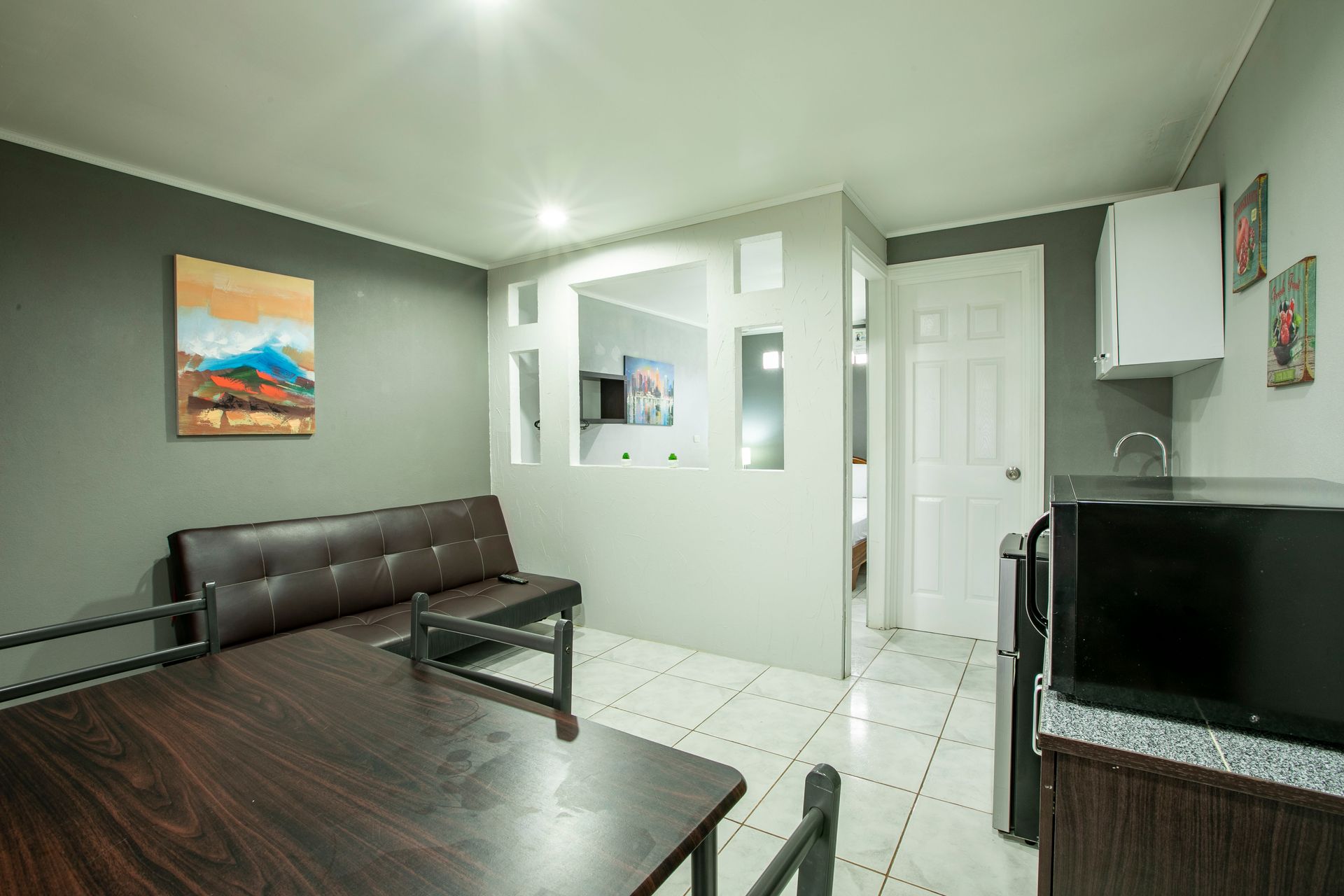 a living room with a couch , table , and microwave .