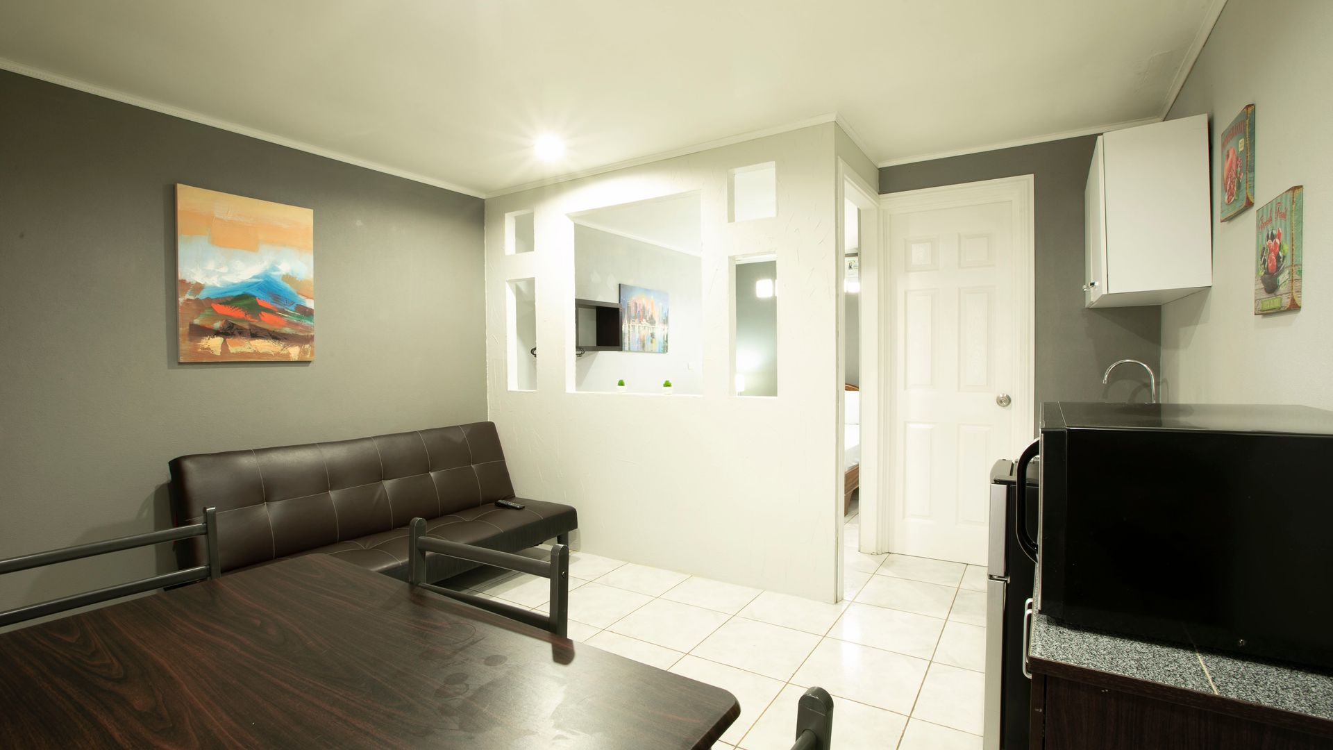 a living room with a couch , table , and microwave .