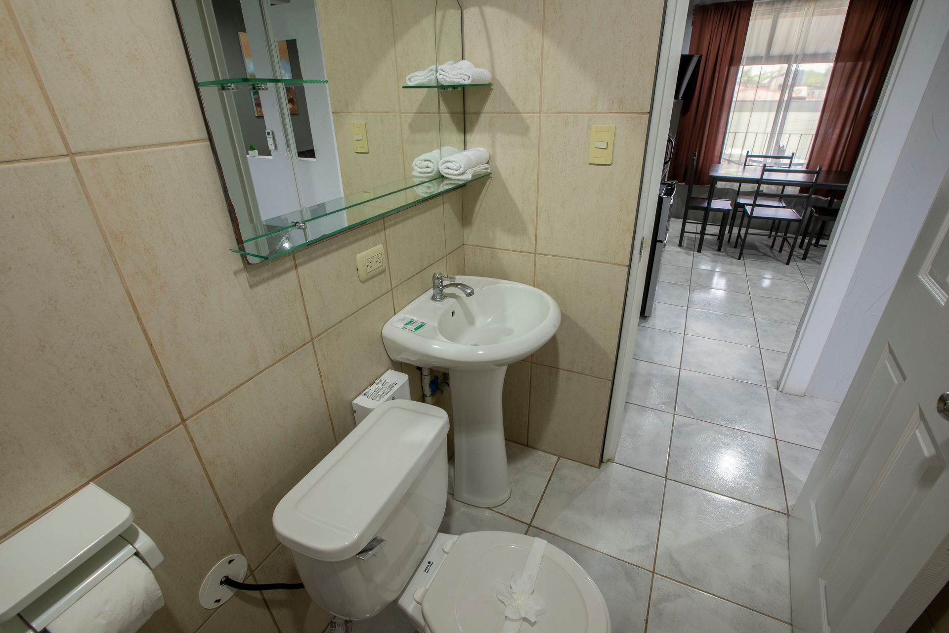 a bathroom with a toilet , sink and mirror .