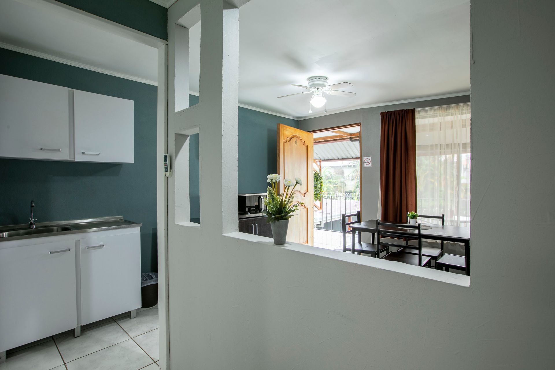 a view of a kitchen and dining room through a doorway .