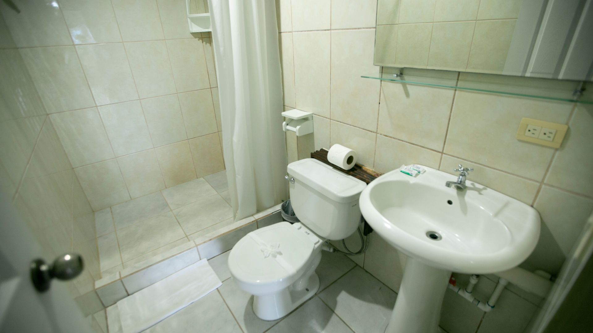 a bathroom with a toilet , sink and shower .