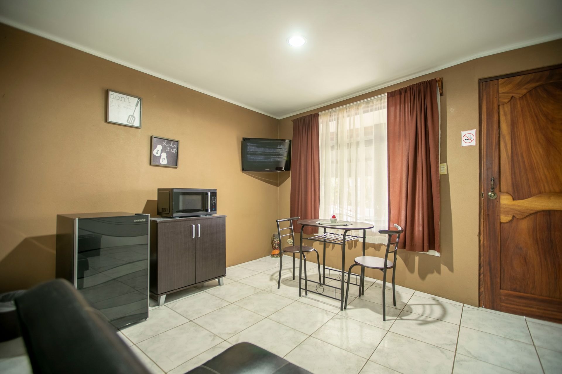 a living room with a table and chairs and a television .