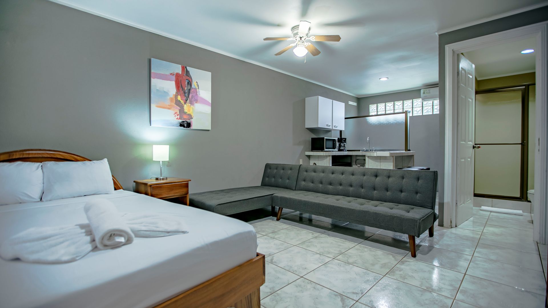 a hotel room with a bed , couch , and kitchen .