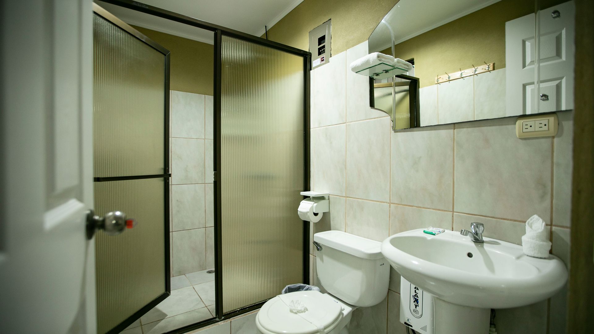 a bathroom with a toilet , sink and shower .