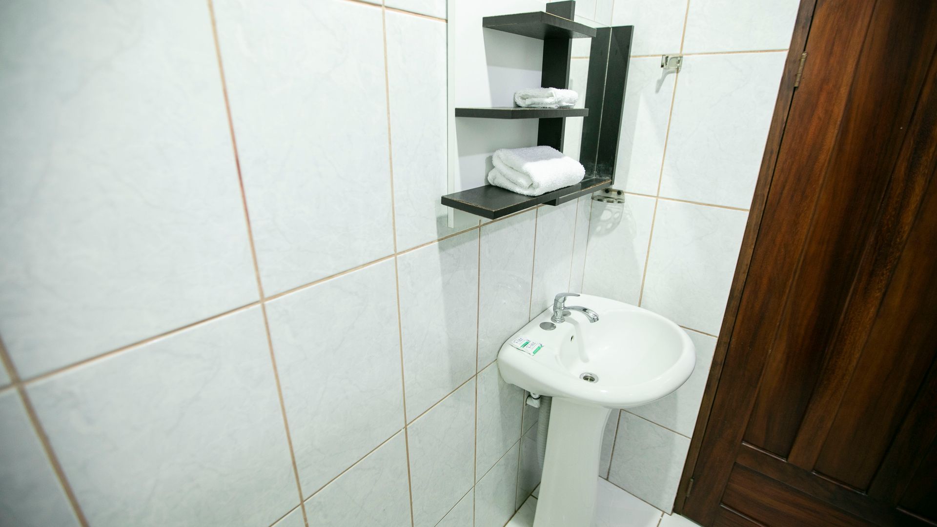 a bathroom with a sink and a shelf with towels on it .
