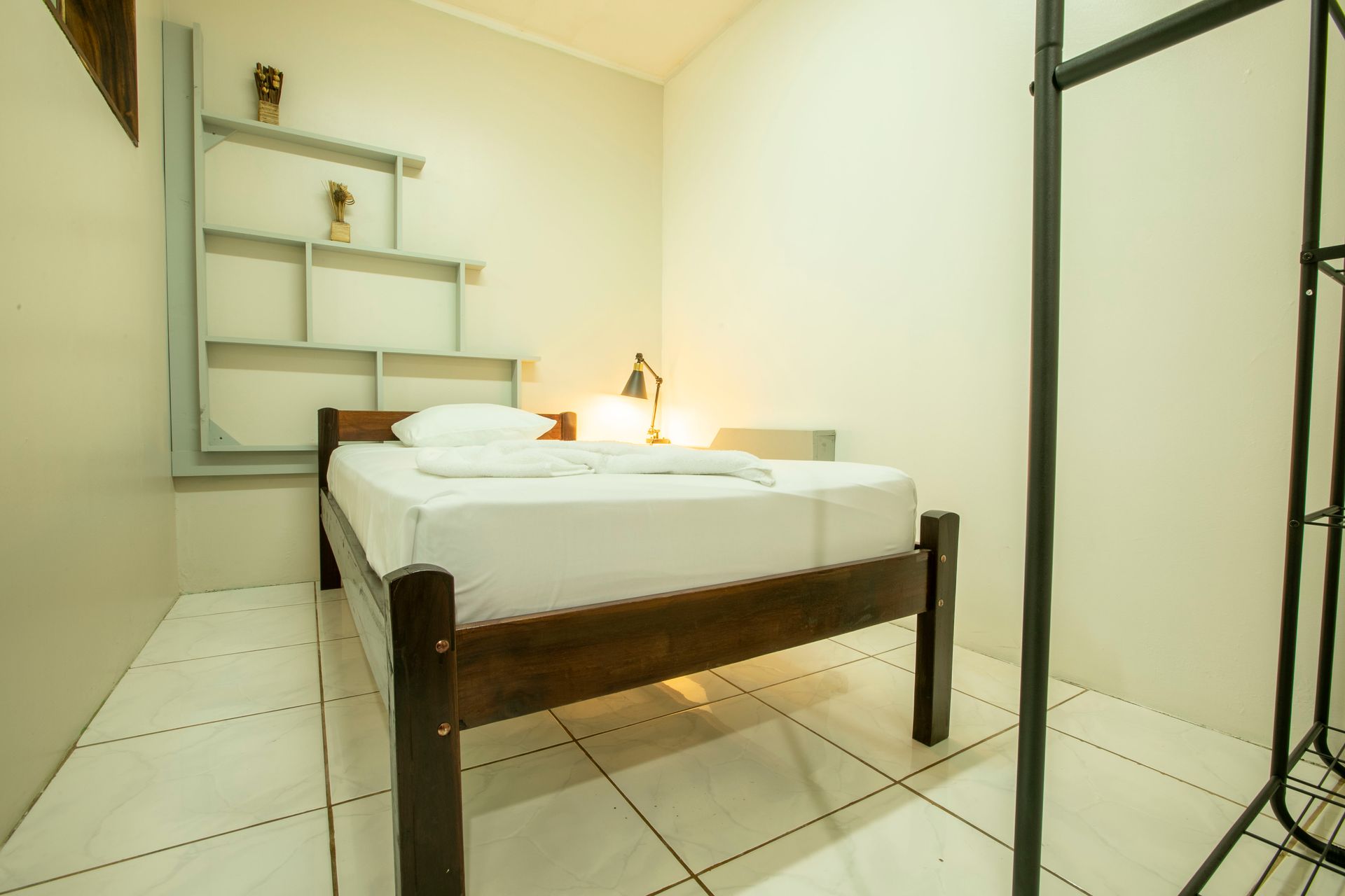 a small bedroom with a bed and a shelf