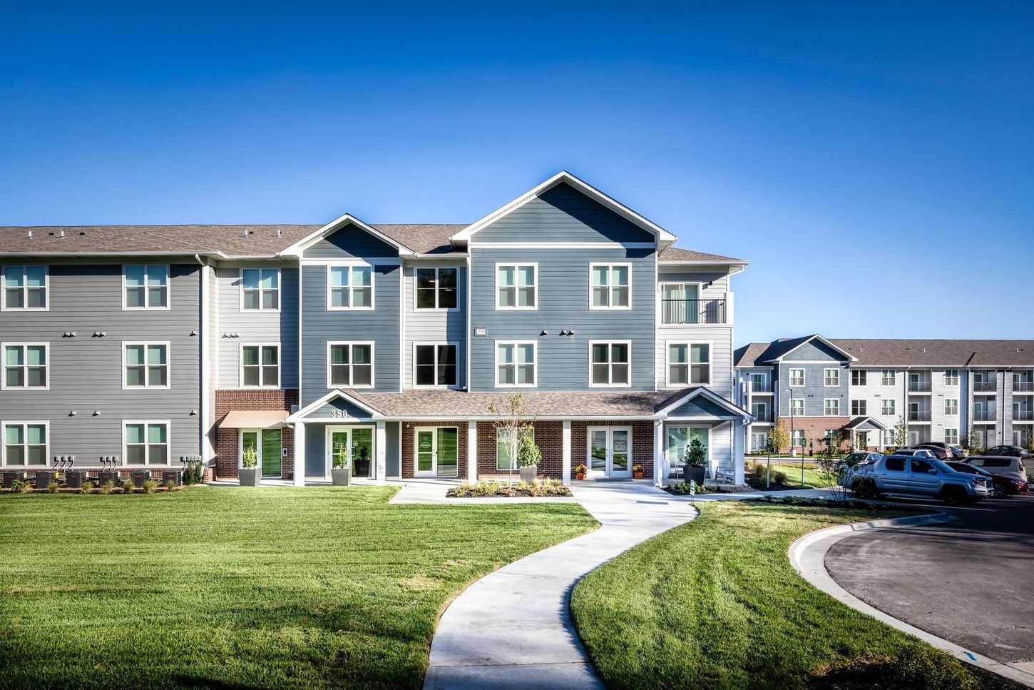 A large apartment building with a walkway leading to it.