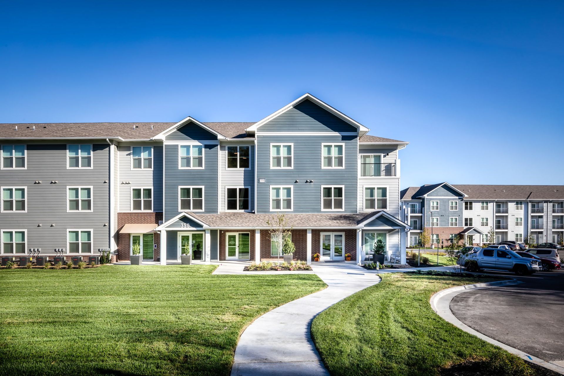 A large apartment building with a walkway leading to it.