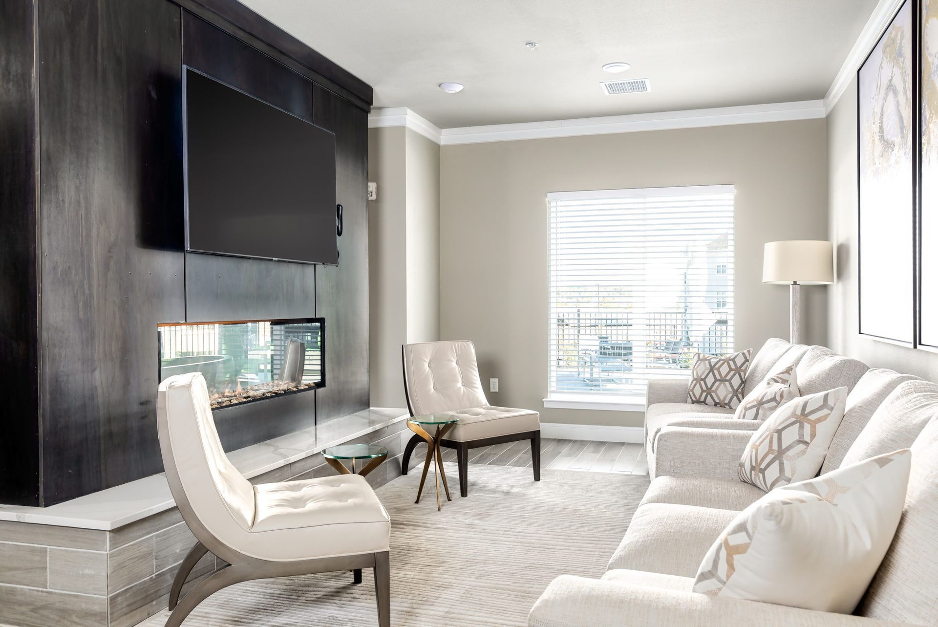 A living room with a couch , chair , television and fireplace.