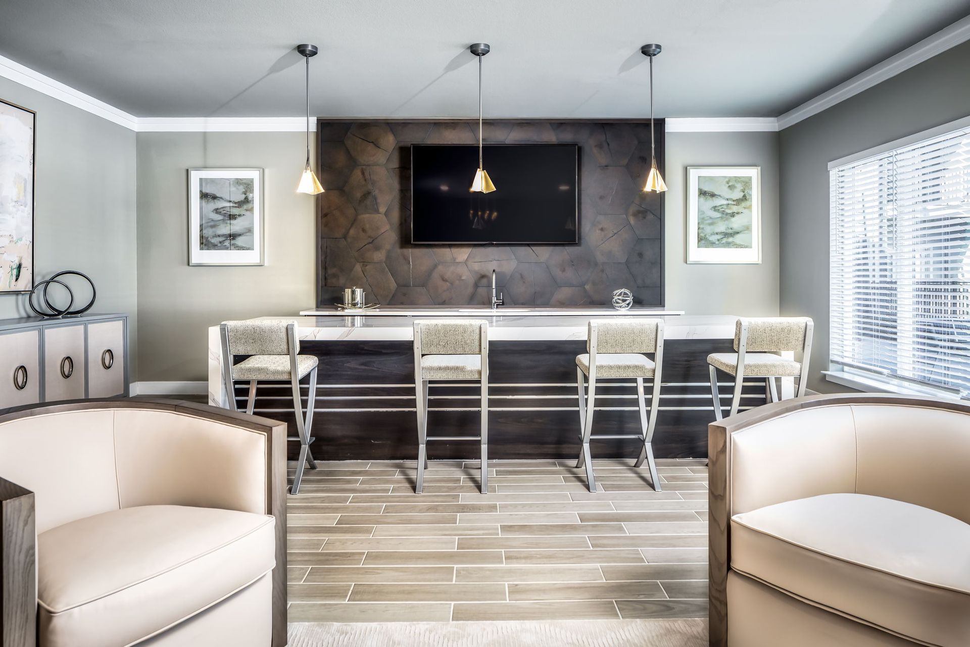 A living room with a bar and chairs and a flat screen tv