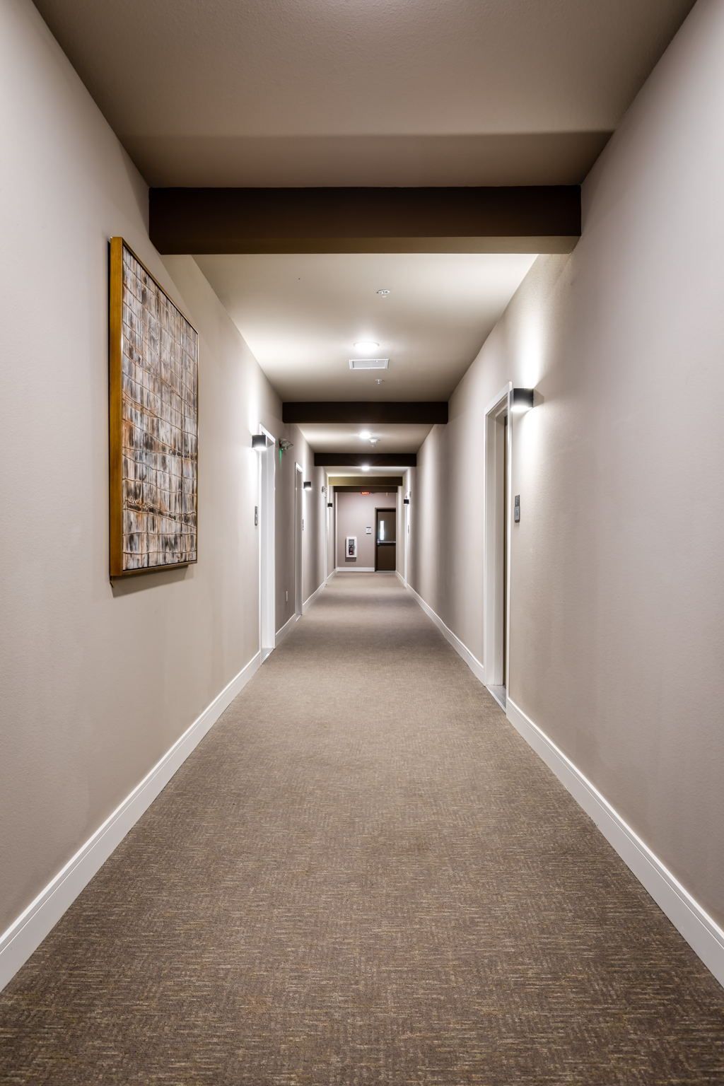 A long hallway with a painting on the wall.