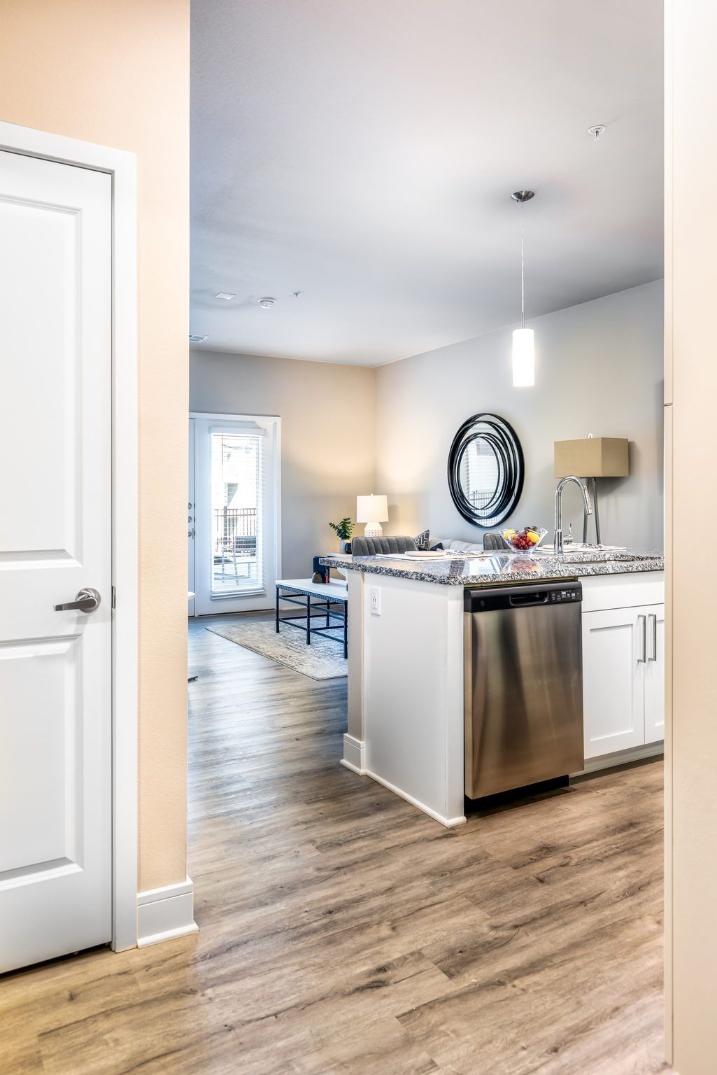 A kitchen with stainless steel appliances and hardwood floors in a house.