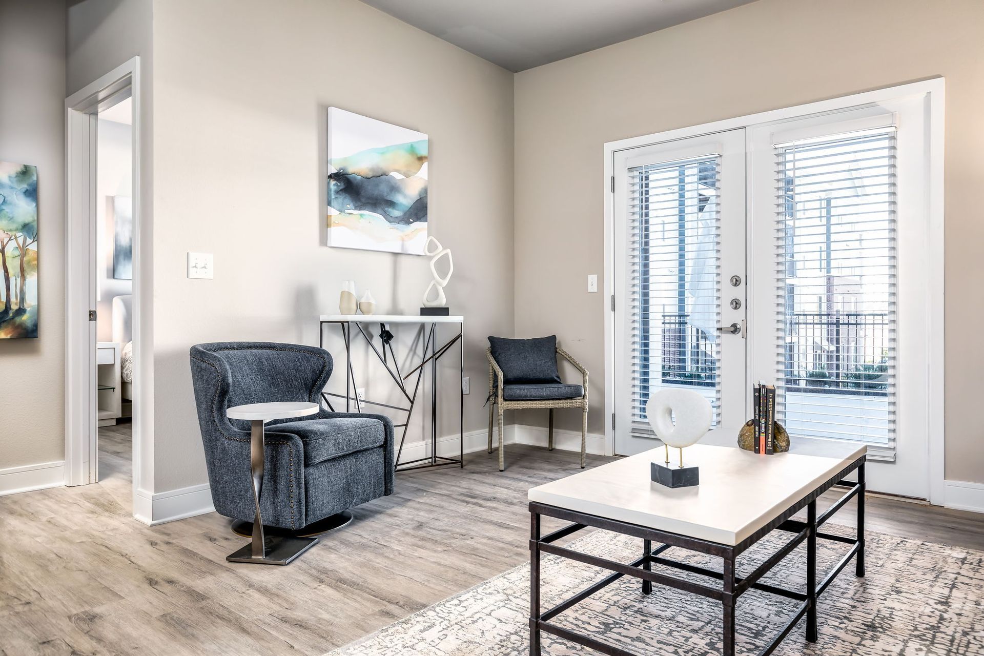 A living room with a chair , coffee table , and sliding glass doors.