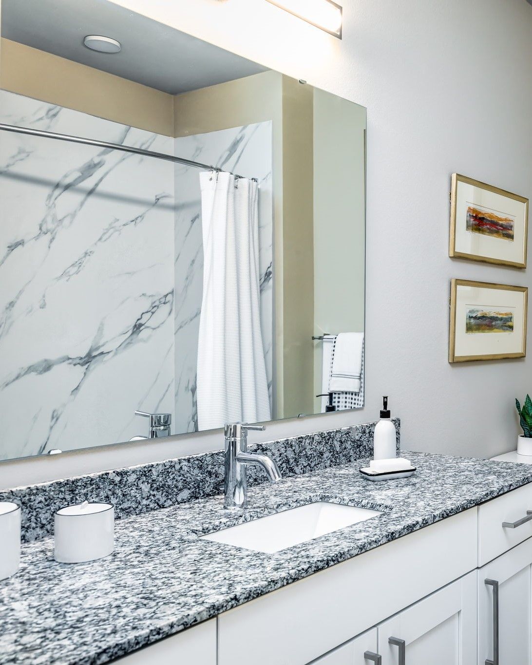 A bathroom with a sink and a large mirror