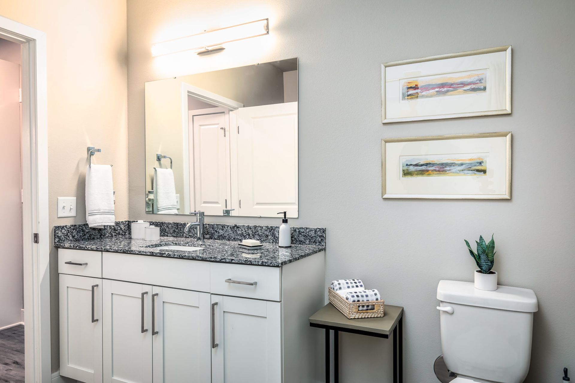 A bathroom with a sink , toilet and mirror.