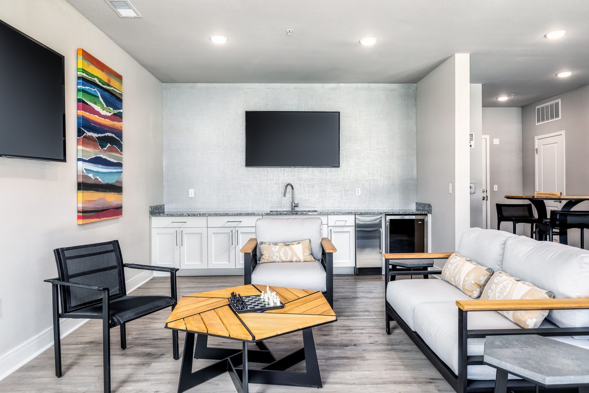 A living room with a couch , chairs , table and television.