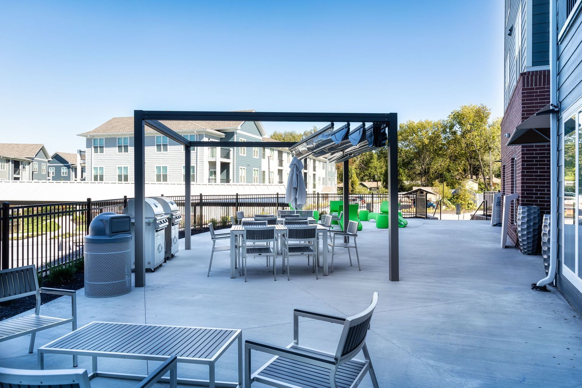 A patio with a table and chairs and a grill.