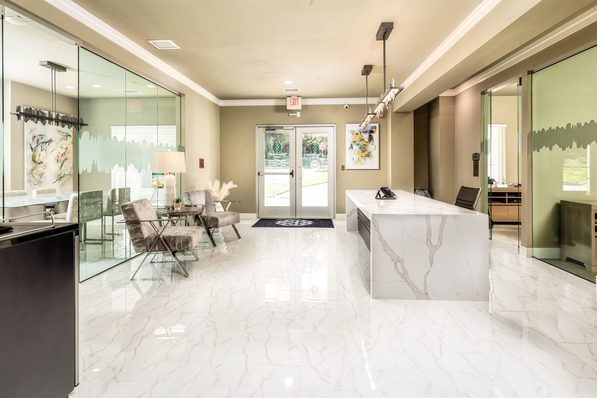 A large lobby with a marble floor and a large white counter.