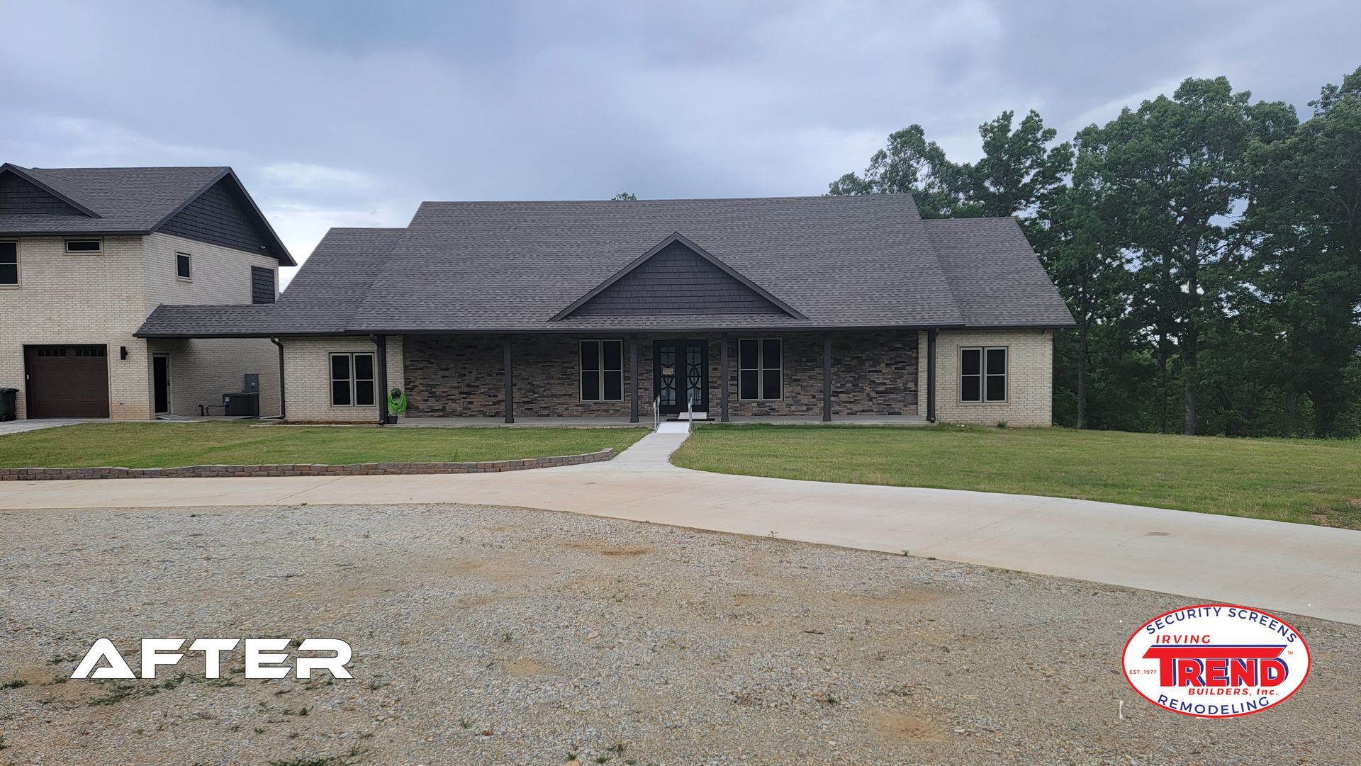 A large house with a gray roof and a driveway in front of it.