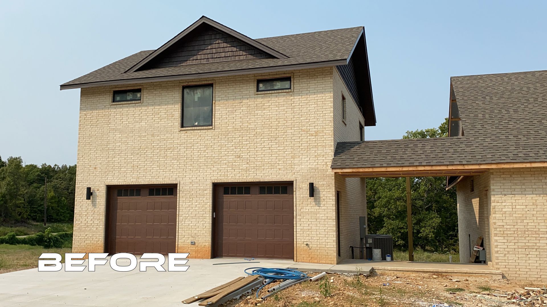 A before picture of a house with two garage doors
