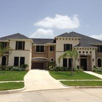 A large house with a lot of windows and a driveway leading to it.