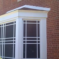 A screened in porch on the side of a brick building.