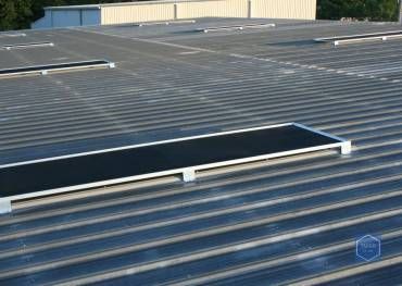 A roof with a row of solar panels on it.