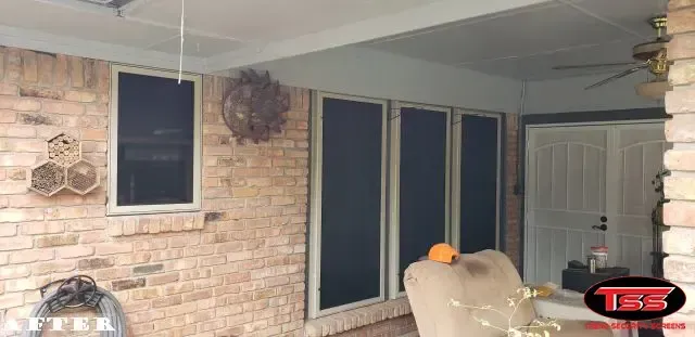 A living room with a brick wall and a ceiling fan.
