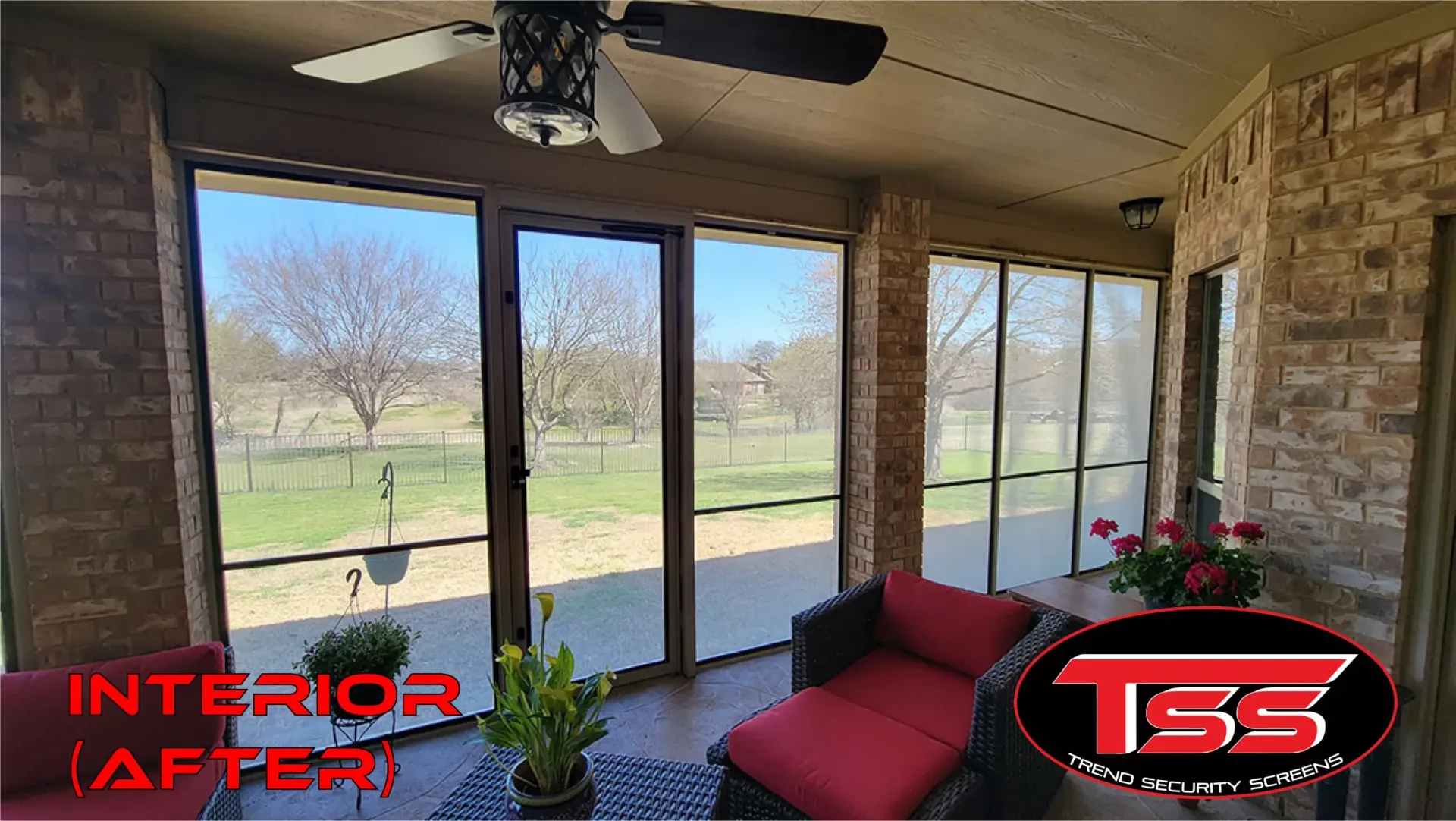 A screened in porch with a lot of windows and a ceiling fan.