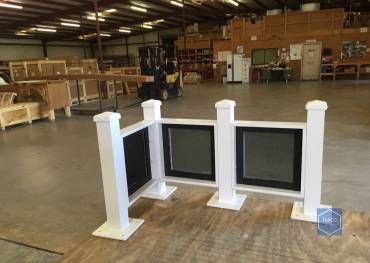 A white fence is sitting on top of a wooden table in a warehouse.