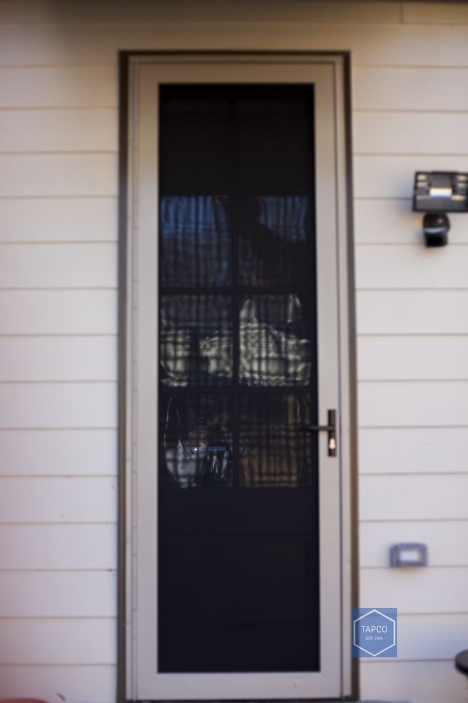 A white door with a black screen on it