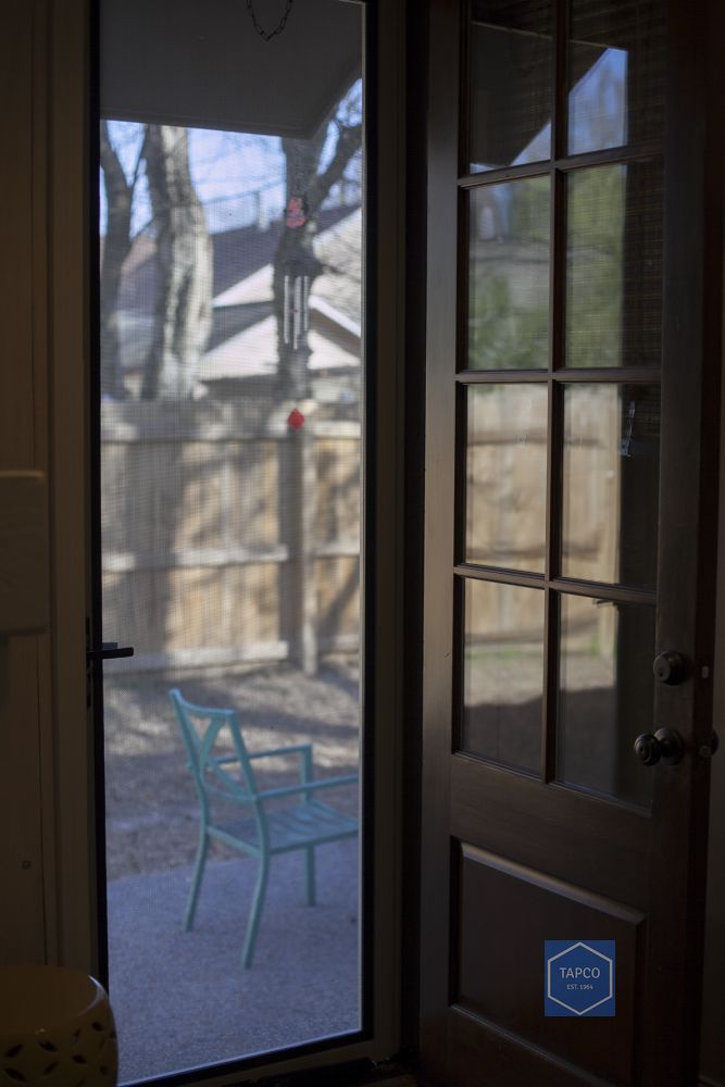 A screened in porch with a chair and a fence