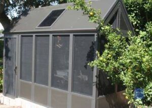 A screened in porch with a solar panel on the roof.