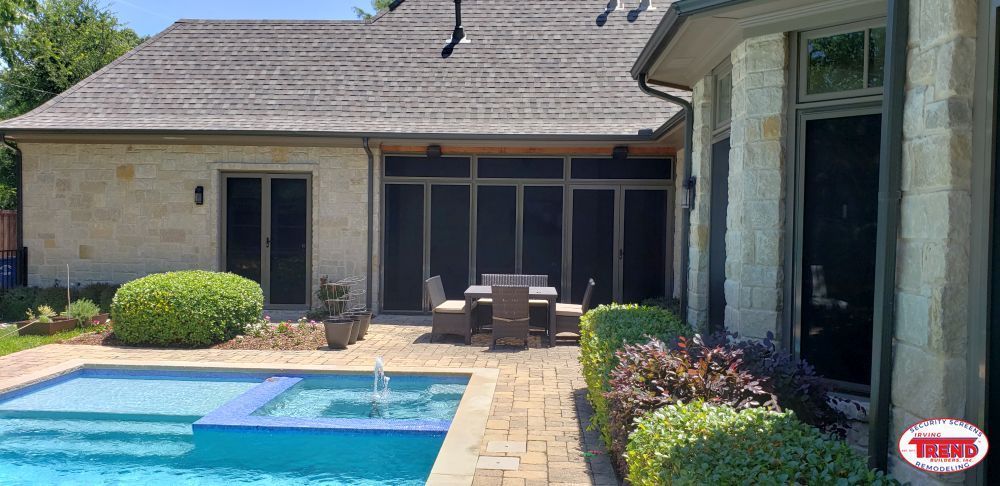 There is a large swimming pool in the backyard of a house.