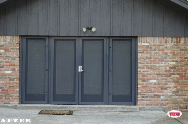 A picture of a brick building with a black screen door