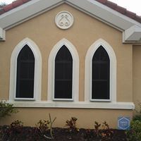 There are three arched windows on the side of a building.