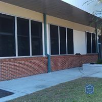 A large brick building with a lot of windows and a sidewalk.