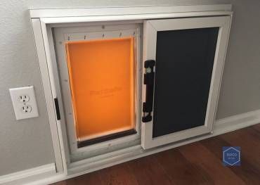 A dog door is built into a wall in a room.